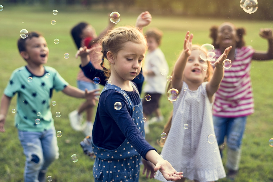 Group Of Kindergarten Kids Friends Playing Blowing Bubbles Fun