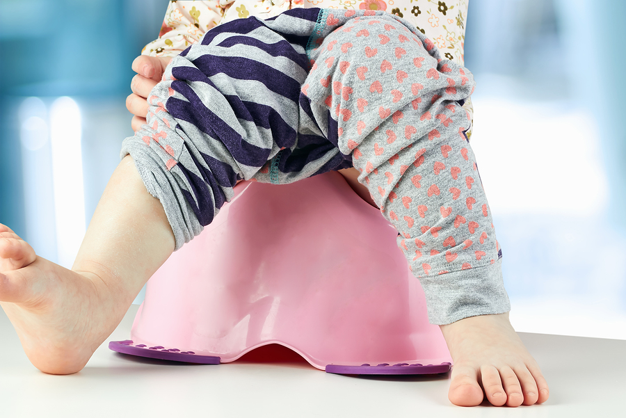 Children's Legs Hanging Down From A Chamber Pot